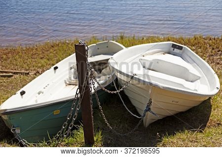 Umea, Norrland Sweden - June 8, 2020: Two Leisure Boats Locked With Chains On Land