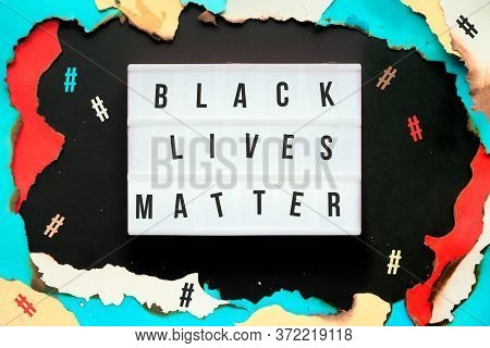 Blm Movement. Paper Hole With Burned Edges, Text Black Lives Matter On Lightbox Surrounded By Hashta