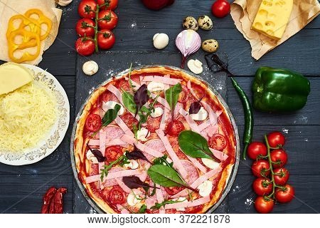 Raw Pizza With Mozzarella Cheese, Meat, Tomatoes, Mushrooms, Peppers, Herbs On A Dark Wooden Backgro