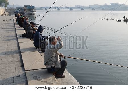Pyongyang, North Korea - May 1, 2019: Local Fishermen Catch A Fish On Waterfront On Kim Il Sung Squa
