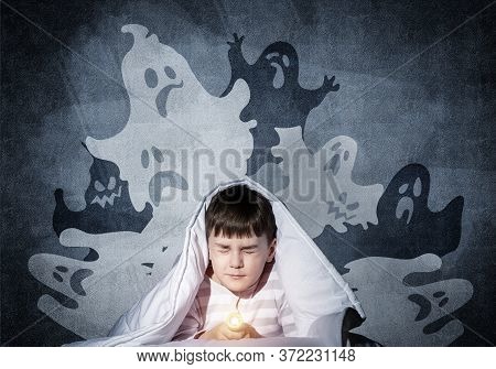Frightened Child With Flashlight Hiding Under Blanket. Scared Kid With Closed Eyes Lying In Bed At H