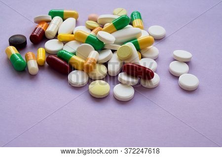 Colorful Pills And Capsules On A Purple Background, Macroshot Tablets