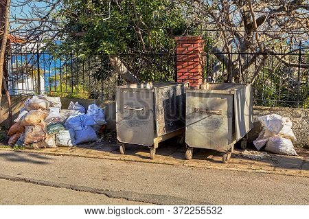 Istanbul, Turkey - February 13, 2020: A Pile Of Garbage Bags Stacked Near Steel Trash Cans On The Si