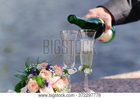 Hand Pouring Champagne Into Wedding Glasses Close Up