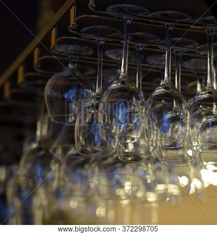Clean Wine Glasses Prepared By Bartender And Hung On The Bar At A Restaurant Or Cafe. Glasses Prepar