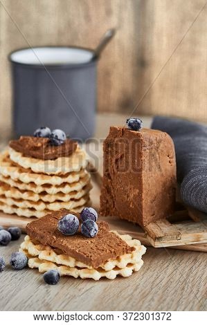 Viennese Waffles With Norwegian Brunost Cheese And Blueberries With A Cup Of Coffee In The Backgroun