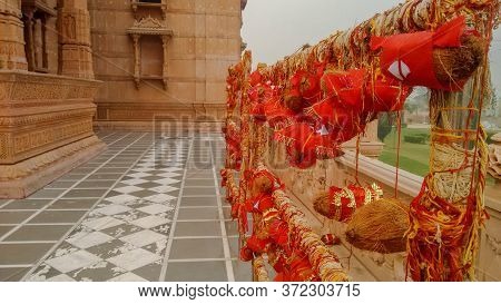 Prayer Coconuts Wrapped In A Red Cloth Tied With Red Threads To The Poles By The Devotees In A Corri