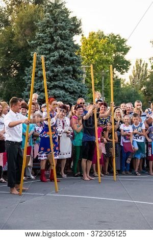 Genichesk, Ukraine - August 26, 2017: Men Compete In Walking On Wooden Stilts During Festival Tavriy