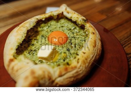 Khachapuri Made From A Delicious Tender Dough With Spinach, Melted Cheese And Butter Close Up. Tradi