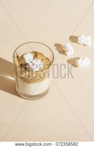 Dalgon Coffee In A Transparent Glass With Milk On A Pastel Background With Marshmallows.