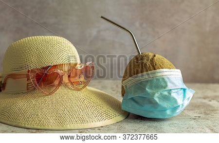Summer 2020 Concept. Coconut In Medical Masks And Straw Beach Hat With Sunglasses. Sea Vacation Duri