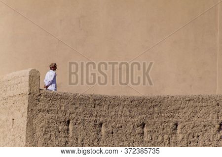 Bahla, Oman - February 27, 2017: Local Man At A Wall Of Bahla Fort, Oman