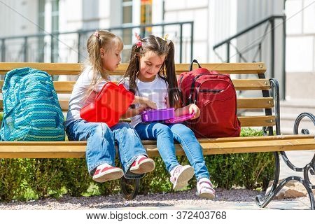 Elementary School Kids Sitting With Packed Lunches
