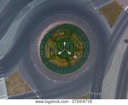 Roundabout At City Streets With Plants And High Lamp At Center
