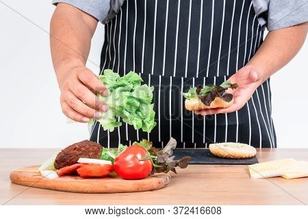 The Butler Is Cooking A Hamburger Which Contains Fres Vegetables, Meat And Sheese, Is A Food That Is