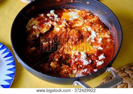Shakshuka In A Frying Pan. Eggs Poached In Spicy Tomato Pepper Sauce