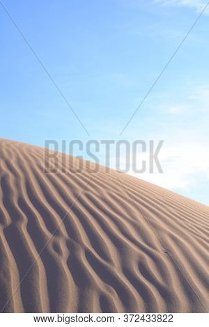 Sand Dunes And Ripples In The Desert On A Clear, Sunny Day