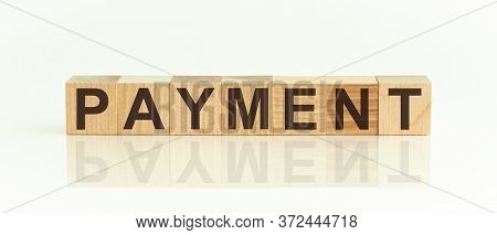 Wooden Blocks With The Text: Payment. The Text Is Written In Black Letters And Is Reflected In The M