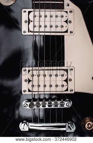 Black And White Electric Bass Guitar. Musical Instrument Close-up. Stylish Still Life With Parts Of 