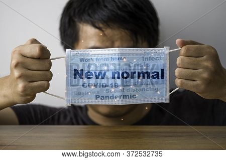 Man Hand Holding Surgical Face Mask Which Print Screen New Normal Working And Others Such As Covid19