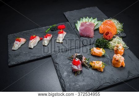 Sushi, Traditional Japanese Cuisine. Several Delicious Sushi On The Decorated Plate, Black Backgroun