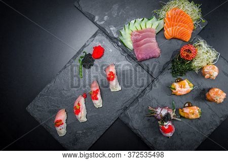 Sushi, Traditional Japanese Cuisine. Several Delicious Sushi On The Decorated Plate, Black Backgroun