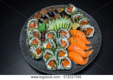 Sushi, Traditional Japanese Cuisine. Several Delicious Sushi On The Decorated Plate, Black Backgroun