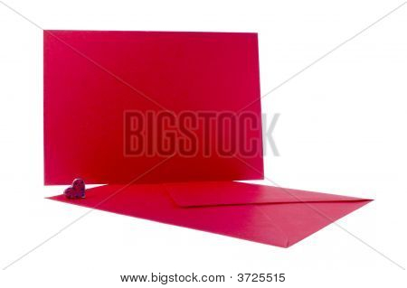 Busta rossa e carta con cuore su sfondo bianco