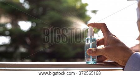 Young Man Uses A Spray Of Alcohol To Get Rid Of Bacteria And Viruses, Inhibition And Prevention Of C