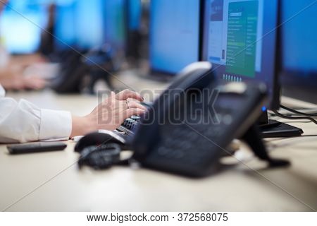 Group of Security data center operators working in a CCTV monitoring room looking on multiple monitors  Officers Monitoring Multiple Screens for Suspicious Activities  Team working on the System Contr