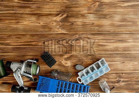Flat Lay With Fishing Tackle, Fishing Rod And Plastic Box With Fishing Tackle And Hooks, Feeders On 