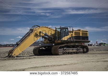 A Large Excavator Sits In An Urban Development As This Piece Of Machinery Is Assembled And Requires 