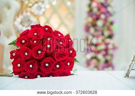 Set Of Wedding Rings In Red Rose Taken Closeup . Bride And Groom Rings On A Red Wedding Bouquet. A B