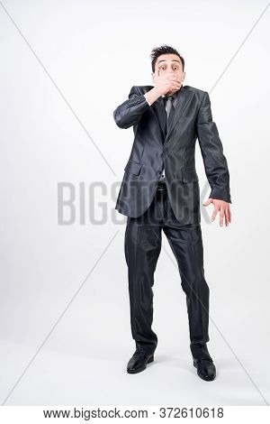 Man In Suit Covering His Mouth