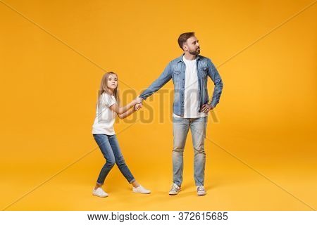 Obstinate Bearded Man With Child Baby Girl. Father Little Kid Daughter Isolated On Yellow Background