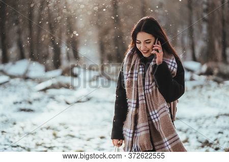 Woman Talking On Mobile Phone. Smiling Girl Talking On Mobile Phone In Cold Winter Day.