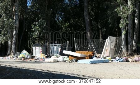 Household Waste Dumped Next To Overflowing Containers In Forest Lay-by