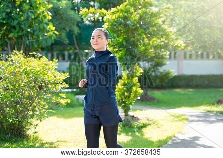 Portrait Of Asian Woman Workout Before Running At Village Park. Cheerful Runner Stretching And Warmi
