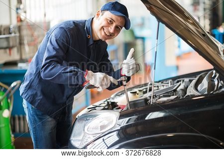 Smiling mechanic giving thumbs up