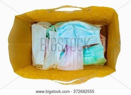 Used Surgical Face Mask In Brown Paper Bag Isolated On White Background. Medical Waste. Infectious W
