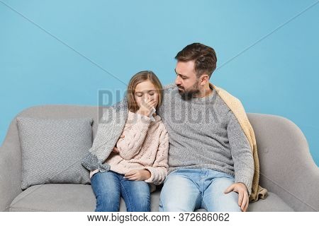 Man In Knitted Sweater With Sick Child Baby Girl. Father Little Daughter Isolated On Blue Background