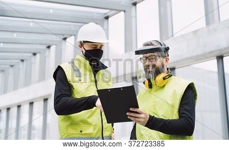 Portrait Of Workers With Face Mask At The Airport, Discussing Issues.