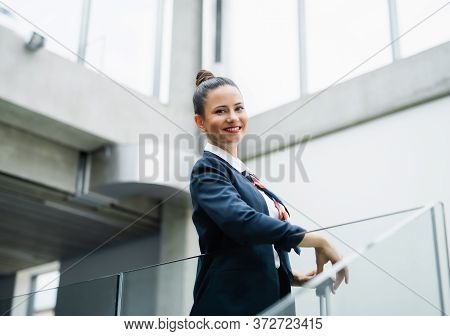 Portrait Of Attractive Flight Attendant Standing On Airport, Looking At Camera.