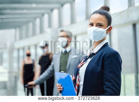 Portrait Of Flight Attendant Standing On Airport, Wearing Face Masks.