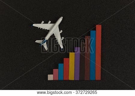 Colorful Chart And Model Airplane On Black Background. Statistics Of Air Travel Concept
