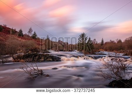 Long Exposure Of Cold Scottish Highland River At Dusk.