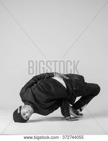 A Man Hip Hop Dancer Or Bboy Freezes In One Pose On A White Background. Bboy Doing Stylish Stunts.