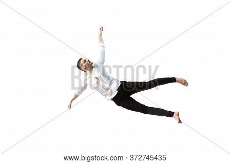 Mid-air Beauty Cought In Moment. Full Length Shot Of Young Man Hovering In Air And Keeping Eyes Clos