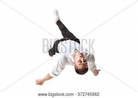Mid-air Beauty Cought In Moment. Full Length Shot Of Young Man Hovering In Air And Keeping Eyes Clos