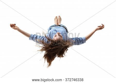 Mid-air Beauty Cought In Moment. Full Length Shot Of Attractive Young Woman Hovering In Air And Keep